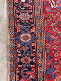 An antique hand-knotted Persian wool rug with an all-over tribal pattern.