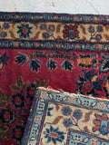 1930s antique Persian rug close-up showing thick wool texture and vibrant floral details.