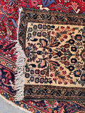 Bedside small antique Persian runner mat top-view detailing the distressed end fringe and historical character.