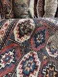 Detail of antique Kazak rug medallion with geometric tribal star design.