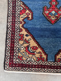 Corner view of antique French blue runner rug with geometric flowers and stylized fish motifs.