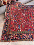 A traditional antique Persian rug hand-woven in rich tones.