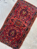 Hand-knotted floral Sarouk rug with central blossoms and flowering branches.
