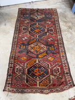Full body shot of eagle Kazak rug with four large medallions on a red field.