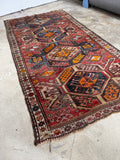 Diagonal shot showing rug’s pop of turmeric yellow and symbolic motifs.