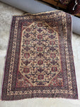 Antique Afshar Persian rug with geometric floral medallions on an earthy field.