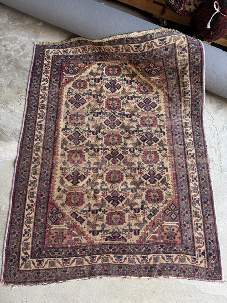 Antique Afshar Persian rug with geometric floral medallions on an earthy field.