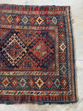 Antique Kazak rug full view with medallion pattern and protective border design.