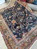 Antique Persian Mahal rug with abrashed navy blue ground and botanical motifs.