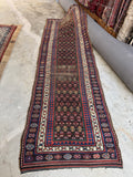 Antique Persian village runner 3'5 x 10'10 with espresso brown field and geometric tribal motifs.