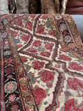 Hand-knotted Persian wool runner showing stepped diamond lattice framing floral motifs.