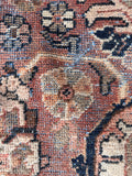Vintage Persian area rug detail showing distressed field texture.