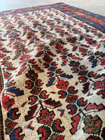 Rug with rich red, deep blue, and earthy green accents.