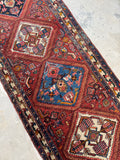 Close-up of multi-step diamond medallions on rust red background.