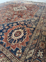 1920s Shiraz rug featuring floral geometric medallion and corner motifs.
