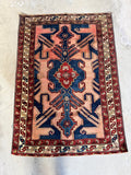 Antique Persian rug showing natural color variation and bold design.