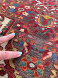 Antique Persian accent rug showing saturated vegetable dyed wool.