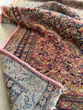 Underside view of the fine weaving and floppy handle of this antique 1880s Persian rug.