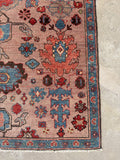 Corner view of floral border detail on vintage Heriz rug with French blue tones.