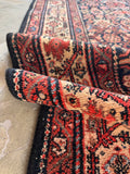 Paisley and floral border Persian rug texture detail illustrating hand-spun vegetable-dyed wool yarns.