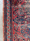 1920s handwoven Persian rug close-up highlighting edge binding and worn texture.