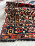 Antique Kurdish rug with a French blue border and geometric tribal spandrels.