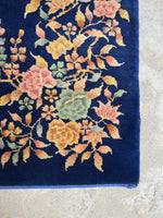 Dark navy blue Art Deco Chinese rug with floral design in the corners.