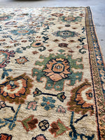 Antique rug with stylized paisley motifs against blue ground.