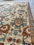 Antique rug with stylized paisley motifs against blue ground.