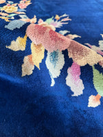 Chinese Art Deco rug featuring pastel floral motifs on a royal blue ground.