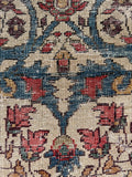 Close-up of a floral patterned fabric with red, blue, and ivory colors.