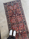 1930s Persian runner featuring botanical patterns and decorative navy and ivory borders.