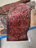 Antique Sarouk floral Persian rug with watermelon pink ground.