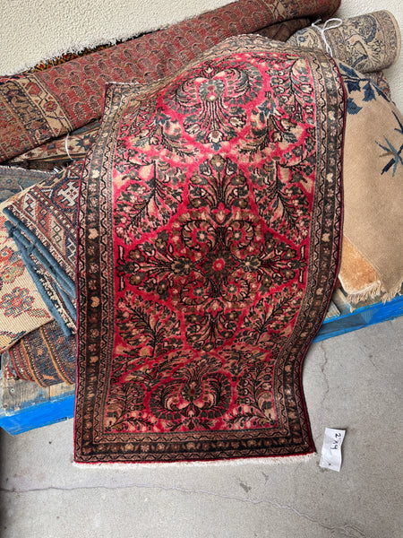 Antique Sarouk floral Persian rug with watermelon pink ground.