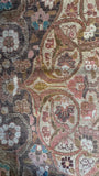 Antique Persian rug featuring fine wool weave, scrolling vines, and ribbon-like teal blue details.