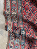 Handwoven Bidjar rug with floral motif border design.