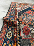 1920s hand-knotted area rug detail showing a French blue floral border and authentic age-worn texture.