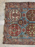 French blue field antique tribal rug with symbolic star motifs and scattered small designs.