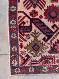 Close up of corner of an antique tribal rug with low pile and distressed worn patina for rustic floor decor.