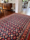 Pink and navy Persian rug field pattern detailed under neutral lighting.