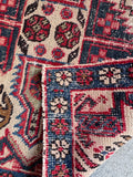 Small tribal scatter rug with a stout, durable low-pile weave on a neutral ivory ground.
