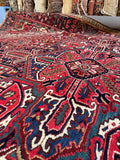 Large Persian Heriz carpet. Antique wool rug with a brick red field, floral chain guard border, and exceptional craftsmanship.