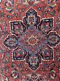Geometric central medallion Heriz rug detail shot focusing on the navy, sky blue, and rust starburst centerpiece.
