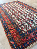 Early 1900s Persian rug featuring rams horn border motif.