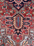 Distressed antique Persian Heriz rug texture close up showing sturdy hand-woven structure and scattered wear.