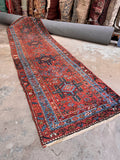 Antique Karaja Persian runner measuring 3’3 x 11’3 featuring a vibrant burnt orange-melon ground and striking tribal art.