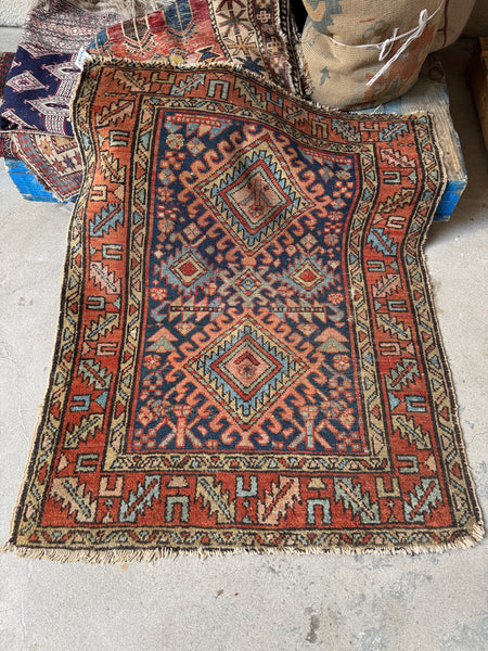 Vintage 1920s Persian Gharajeh Heriz scatter rug with tribal scorpion motif and ram’s horn symbols, navy field, and brick red border.