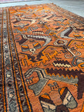 Close-up of Kurdish handwoven orange rug with tribal design.