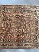 Warm goldenrod details highlighting the artistry of this antique Tabriz.
