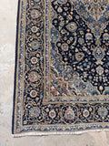 Fine weave Persian Kashan rug featuring floral motifs in rich navy, ivory, and blue.